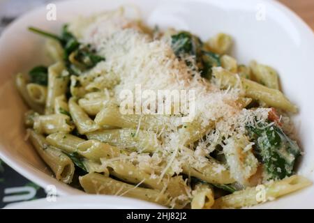 Scampi und Spinaci Pasta mit Penne. Teller mit köstlichen Pasta italienischen Stil. Voller Kohlenhydrate und Fett, aber super lecker! Nahaufnahme des Farbbildes. Stockfoto