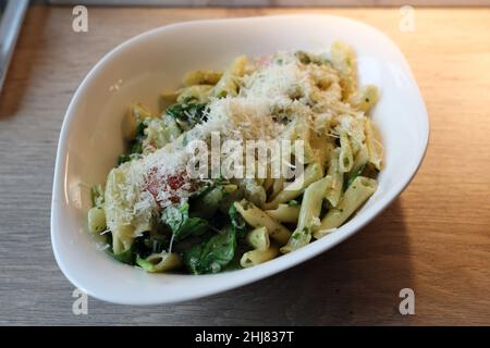 Scampi und Spinaci Pasta mit Penne. Teller mit köstlichen Pasta italienischen Stil. Voller Kohlenhydrate und Fett, aber super lecker! Nahaufnahme des Farbbildes. Stockfoto