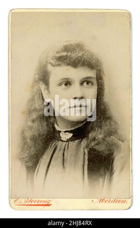 Original viktorianische Epoche Carte de Visite (CDV) eines hübschen schottischen Teenager-Mädchens mit langen Haaren, Brosche am Ausschnitt der Bluse, aus dem Fotostudio von E. Geering, Aberdeen, Schottland, Großbritannien um 1885. Stockfoto