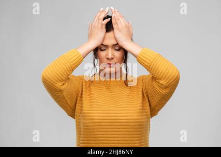 Gestresste junge Frau, die sich am Kopf festhält Stockfoto