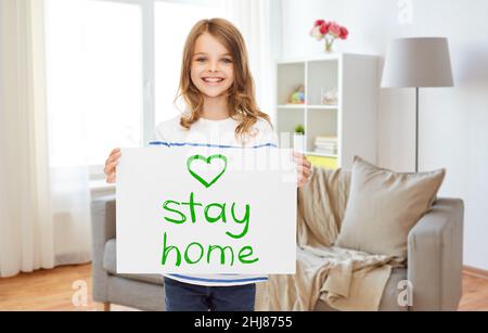 Glückliches Mädchen hält zu Hause bleiben Nachricht auf Papier Stockfoto