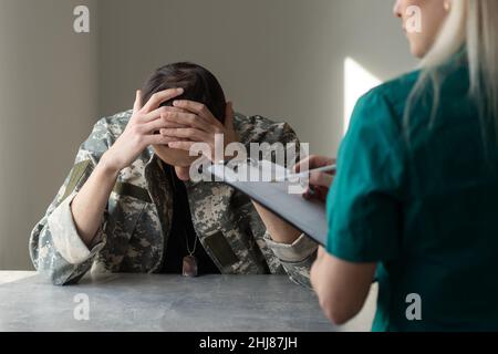 Soldat, der während der Psychotherapie auf dem Sofa sitzt Stockfoto