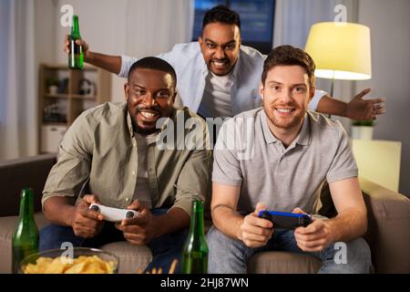 Glückliche Freunde spielen Videospiele zu Hause in der Nacht Stockfoto