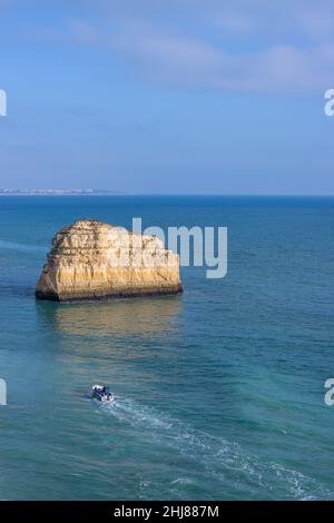 Malerischer Felsen im offenen blauen Meer bei Benagil während des Sonnenuntergangs, Portugal - 30. Dezember 2021 Stockfoto