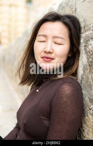 Porträt eines attraktiven 29-jährigen asiatisch-amerikanischen Mädchens mit geschlossenen Augen Stockfoto