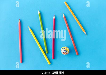 Farbstifte und Gummibänder auf blau Stockfoto