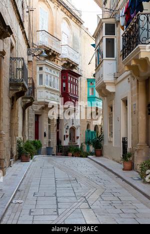 Valletta, Malta - 01 06 2022: Schmale Straße mit Wohnhäusern im mediterranen Stil Stockfoto