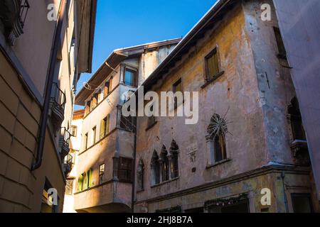 Historische Gebäude mit Weihnachtsschmuck in der norditalienischen Stadt Belluno, Region Venetien. Das Gebäude auf der rechten Seite hat Doppelfenster Stockfoto