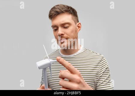 Junger Mann mit Spielzeug-Windturbine Stockfoto