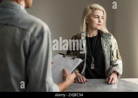 Militärfrau. Blonde erfahrene Militärfrau, die an Schlaflosigkeit leidet, kommt zum Psychologen. Stockfoto