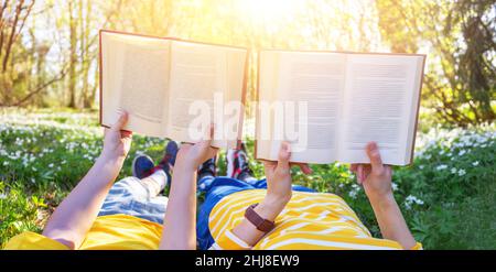 Mutter und ihr Sohn liegen auf dem schönen Frühlingsfeld im sonnigen Park. Stockfoto