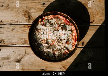 Blick aus der Ferne auf hausgemachte Pizza auf dem Tisch, hausgemachte Pizza Stockfoto