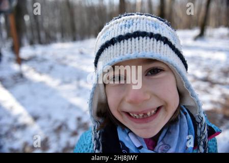 Kind lächelt und macht eine Grimasse, die ihren fehlenden Milchzahn zeigt Stockfoto