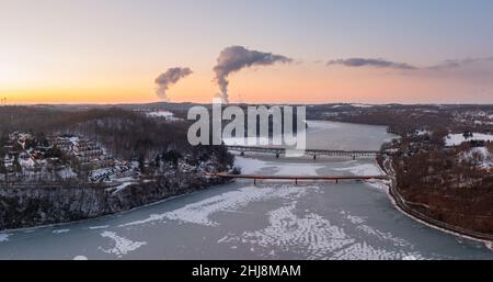 Luftdrohnen-Sonnenuntergangspanorama des frzoen und schneebedeckten Cheat Lake und der Interstate i68 Brücke in der Nähe von Morgantown, West Virginia Stockfoto