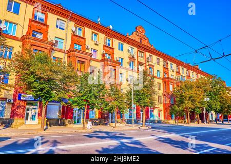 ZAPORIZHZHIA, UKRAINE - 25. AUGUST 2021: Wohngebäude aus der Sowjetzeit im Prospekt Sobornyi (Avenue) mit schnellem Verkehr im Vordergrund, auf Au Stockfoto