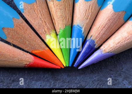 Bunt gefärbte Bleistifte mit scharfen Punkten in den Farben des Regenbogens, die in einem Halbkreis angeordnet sind Stockfoto