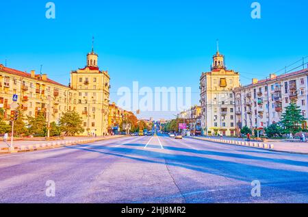 SAPORISCHSCHSCHJA, UKRAINE - 25. AUGUST 2021: Der breite Prospekt Sobornyi (Allee) mit historischen Türmen der sozialrealistischen Gebäude der Sowjetzeit, Stockfoto