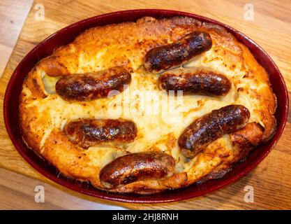 Kochen hausgemachte Kröte in the Hole oder Würstchen im Teig Stockfoto