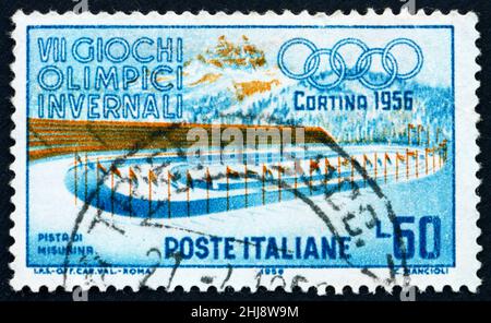 ITALIEN - UM 1956: Eine in Italien gedruckte Marke zeigt Eisrennen, den Misurina-See, die Olympischen Winterspiele 7th in Cortina d’Ampezzo, um 1956 Stockfoto