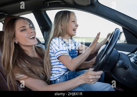 Mama lehrt ihre kleine Tochter zu fahren Stockfoto
