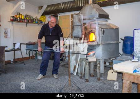 Murano, Italien - 2. November 2012: Ein Glasmeister bei der Arbeit in seiner Werkstatt. Murano ist eine Reihe von Inseln, die durch Brücken in der Lagune von Venedig miteinander verbunden sind Stockfoto