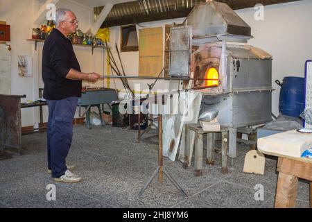 Murano, Italien - 2. November 2012: Ein Glasmeister bei der Arbeit in seiner Werkstatt. Murano ist eine Reihe von Inseln, die durch Brücken in der Lagune von Venedig miteinander verbunden sind Stockfoto