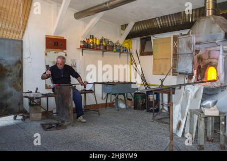 Murano, Italien - 2. November 2012: Ein Glasmeister bei der Arbeit in seiner Werkstatt. Murano ist eine Reihe von Inseln, die durch Brücken in der Lagune von Venedig miteinander verbunden sind Stockfoto