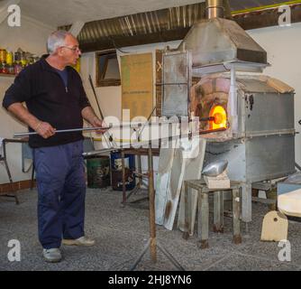 Murano, Italien - 2. November 2012: Ein Glasmeister bei der Arbeit in seiner Werkstatt. Murano ist eine Reihe von Inseln, die durch Brücken in der Lagune von Venedig miteinander verbunden sind Stockfoto