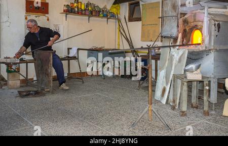 Murano, Italien - 2. November 2012: Ein Glasmeister bei der Arbeit in seiner Werkstatt. Murano ist eine Reihe von Inseln, die durch Brücken in der Lagune von Venedig miteinander verbunden sind Stockfoto