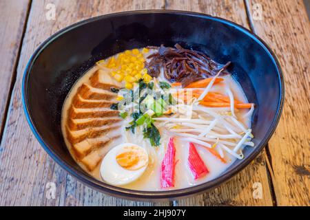 Char Sui Pork Ramen: Eine köstliche Schüssel mit Nudeln in Brühe mit Char sui Schweinefleisch, Ei, Krabbenstäbchen, Sprossen, Karotten, Mais, Frühlingszwiebeln Stockfoto