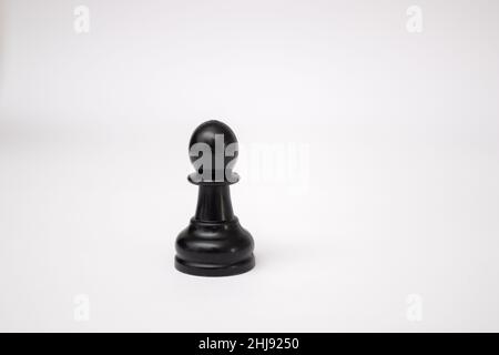 Schwarzes Schachstück weißer Bauer auf weißem Hintergrund. Stockfoto