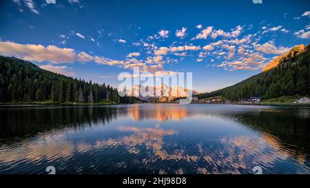 Panoramablick auf den See und die Stadt Misurina, Lago di Misurina, mit dem Berg Punta Sorapiss, der sich im Wasser spiegelt, L’istituto Pio XII. Stockfoto