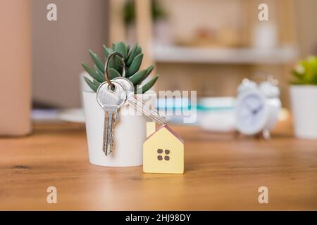 Schlüssel- und hausförmige Schlüsselanhänger auf blauem Hintergrund. Stockfoto