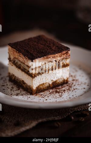 Tiramisu Kuchen Dessert auf einem grauen Hintergrund. Ein Stück traditionelles italienisches Dessert aus Mascarpone-Käse, Kaffee und Keksen Stockfoto