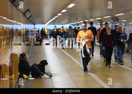 Wölfe Fußballfans, die durch die U-Bahn gingen, passierten am Spieltag einen Bettler mit einem Hund Wolverhampton Wanderers 19/09/2019 City Subway uk unterfahren britische Stadtmenschen beschäftigt Stockfoto