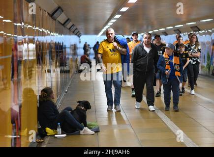 Wölfe Fußballfans, die durch die U-Bahn gingen, passierten am Spieltag einen Bettler mit einem Hund Wolverhampton Wanderers 19/09/2019 City Subway uk unterfahren britische Stadtmenschen beschäftigt Stockfoto