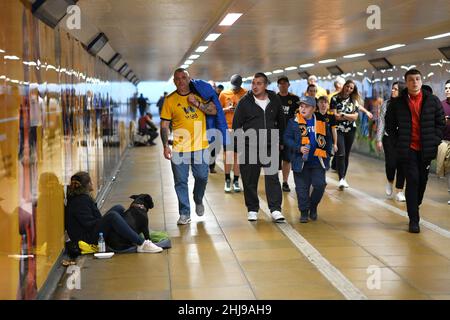 Wölfe Fußballfans, die durch die U-Bahn gingen, passierten am Spieltag einen Bettler mit einem Hund Wolverhampton Wanderers 19/09/2019 City Subway uk unterfahren britische Stadtmenschen beschäftigt Stockfoto