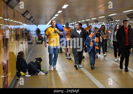 Wölfe Fußballfans, die durch die U-Bahn gingen, passierten am Spieltag einen Bettler mit einem Hund Wolverhampton Wanderers 19/09/2019 City Subway uk unterfahren britische Stadtmenschen beschäftigt Stockfoto