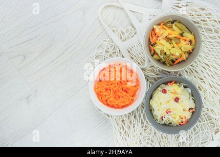Fermentierte konservierte vegetarische Nahrung Konzept. Sauerkraut, eingelegte Karotten und eingelegte Gurken auf weißem Hintergrund. Probiotika Lebensmittel. Draufsicht. Kopie en Stockfoto