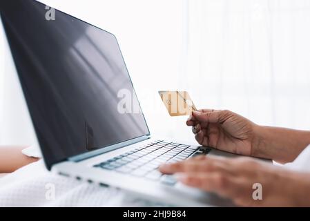 Crop Frau mit Kreditkarte und Laptop Stockfoto