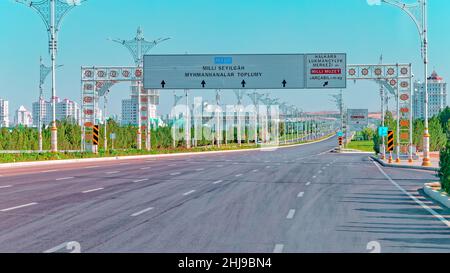 Stadtbild des Stadtzentrums von Ashgabat mit breiter Autobahn und leichtem Verkehr. Hohe Gebäude aus weißem Marmor an den Seiten. Aschgabat ist die Hauptstadt der Turkmenen Stockfoto