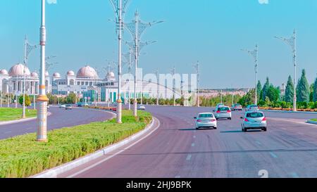 Stadtbild des Stadtzentrums von Ashgabat mit breiter Autobahn und leichtem Verkehr. Hohe Gebäude aus weißem Marmor an den Seiten. Aschgabat ist die Hauptstadt der Turkmenen Stockfoto