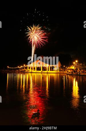 Feuerwerk über dem Shawnee Park Pavillon. 4th. Juli, Unabhängigkeitstag, Feier. Im Vordergrund schwimmt eine Ente. Shawnee Park, Xenia, Dayton, Ohio, USA. Stockfoto