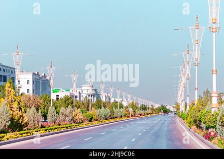 Stadtbild des Stadtzentrums von Ashgabat mit breiter Autobahn und leichtem Verkehr. Hohe Gebäude aus weißem Marmor an den Seiten. Aschgabat ist die Hauptstadt der Turkmenen Stockfoto