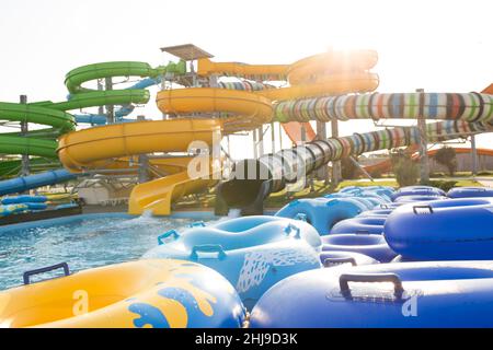 Große und verschiedene Hügel im Wasserpark, während des Sommerabends, mit gleitenden Baloons an der Front. Stockfoto