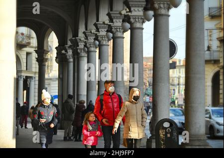 Die Touristenfamilie zu Fuß in einer Innenstadt mit Schutzmasken, Turin Italien Januar 7 2022 Stockfoto