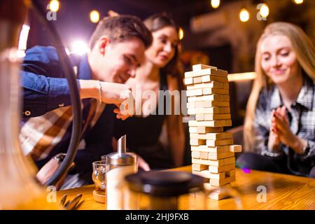 Junge Leute haben Spaß beim Spielen von Brettspielen an einem Tisch Stockfoto