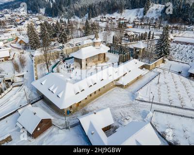 Luftaufnahmen des Klosters Voronet, gelegen im Landkreis Suceava, Rumänien im Winter, sonniger Tag mit Schnee. Das Foto wurde von einer Drohne aufgenommen. Stockfoto