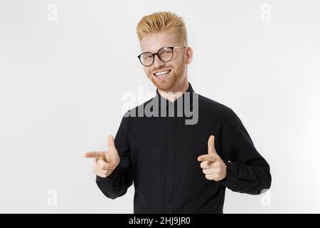 Happy stylish Kerl in schwarzem Hemd und Brille zeigt Kopie Raum. Erfolgreicher junger Mann Unternehmerkonzept. Rothaariger Mann mit rotem Bart. Starten, y Stockfoto