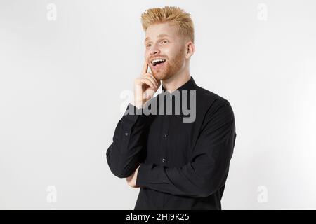 Fröhlicher stylischer Kerl in schwarzem Hemd. Gefaltete Arme, Platz kopieren. Erfolgreiches junges, Entrepreneur-Konzept. Rothaariger Mann mit rotem Bart. Start up, jung gefunden Stockfoto